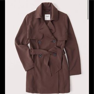dark brown drapey trench coat with hint of red